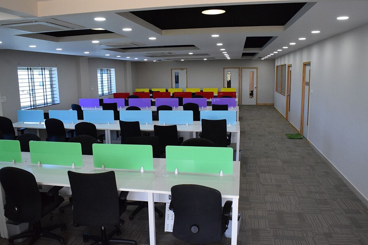 Rady pracovných stolov s farebnými priečkami v coworkingovom centre