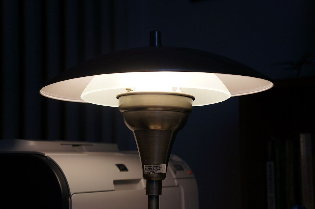 Rozsvietená stolná lampa v tmavej miestnosti